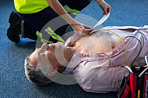 Paramedic using an external defibrillator during cardiopulmonary resuscitation