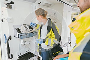 Paramedic using medical technology in ambulance car