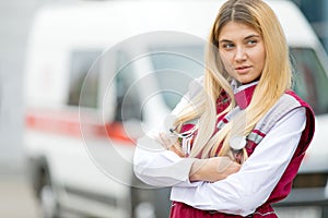 Paramedic worker with phonendoscope at emergency car background