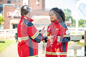 Paramedical personnel dressed in red uniforms standing outdoors