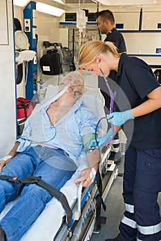 Paramedical team examining patient on stretcher