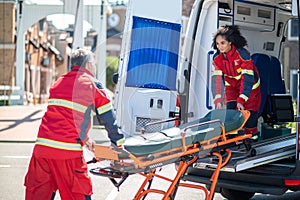 Paramedical workers taking a stretcher out of the EMS vehicle