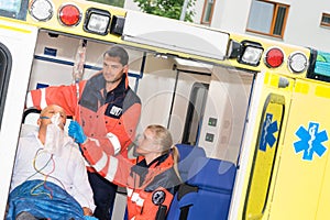 Paramedics checking IV drip patient in ambulance