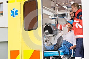 Paramedics checking IV drip patient in ambulance photo