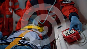 Paramedics hands in gloves providing emergency care of patient in ambulance car