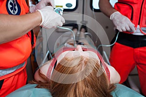 Paramedics helping woman inside ambulance photo