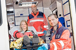 Paramedics helping woman on stretcher in ambulance photo