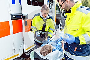 Paramedics measuring blood pressure of injured boy