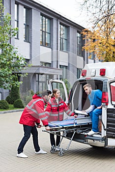 paramedics moving ambulance stretcher