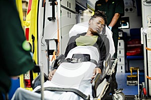 Paramedics moving a patient on a stretcher into an ambulance photo