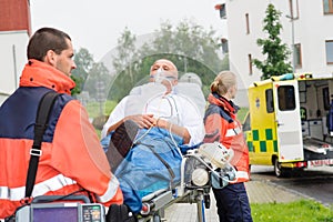 Paramedics with patient on stretcher ambulance aid