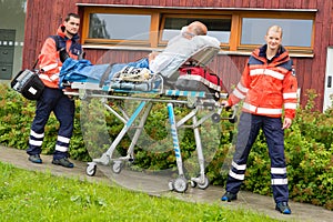 Paramedics with patient on stretcher ambulance aid photo