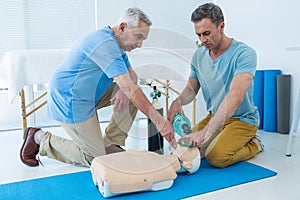 Paramedics practicing cardiopulmonary resuscitation on dummy