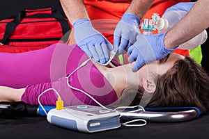 Paramedics using defibrillator on a patient