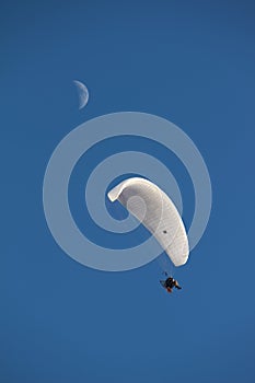 Paramotor in a blue sky with moon