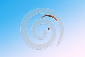 Paramotor flying on blue sky and light of the sun.