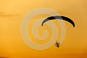 Paramotor / paraglider flying in the sky on sunset sky