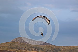 Paramotor pilot flying in the hills of Wales