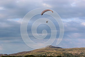 Paramotor pilot flying in the hills of Wales