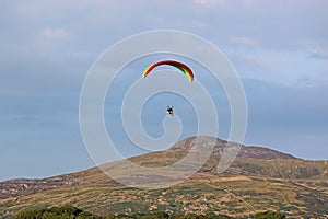Paramotor pilot flying in the hills of Wales