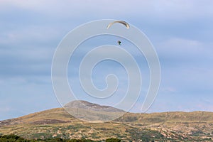 Paramotor pilot flying in the hills of Wales