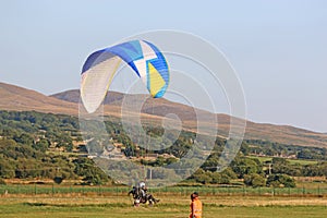 Paramotor pilot taking off in the hills of Wales