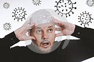 Paranoid man wearing tin foil hat against corona virus covid-19