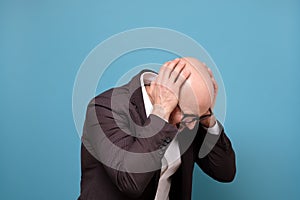 Paranoid mature man covering his ears being annoyed with loud noise.