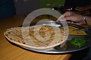 Parantha plate on the table with daal and chutney