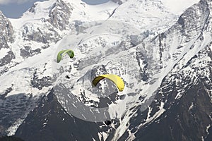 Parapenters flying over french snowy Mont Blanc massif