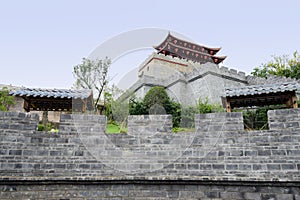 Parapet of ancient Chinese wall with gate tower on mountaintop