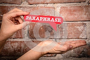 Paraphrase. Red speech bubble with text on a red brick background