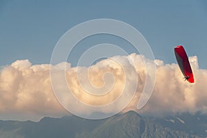 Paraplan flies amid mountains and blue skies with clouds