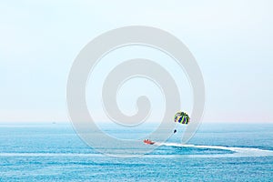 Parasailing in Adriatic sea, Montenegro. Colored parasail wing in blue sky.