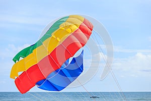 Parasailing, beach umbrella on sky background