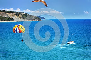 Parasailing with boat over sea in beautiful summer day