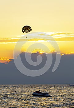 Parasailing and jet ski at sunset