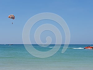 Parasailing over clear blue waters. Different shades of blue in the water