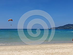 Parasailing over clear blue waters. Different shades of blue in the water