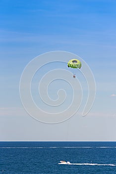 Parasailing over the sea in Salou, Tarragona, Catalunya, Spain. Copy space for text. on blue background. Vertical.