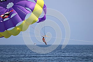 Parasailing on the sea, man flying on parachute