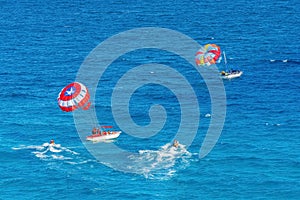 Parasailing towed behind a boat in the Caribbean sea, tropical Ocean, Vacation Concept, Cancun, Mexico