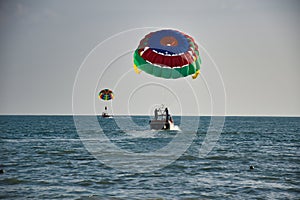 Parasailing on the waves of the azure Andaman sea under the blue sky near the shores of the sandy beautiful exotic and stunning