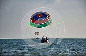 Parasailing on the waves of the azure Andaman sea under the blue sky near the shores of the sandy beautiful exotic and stunning