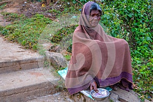 PARASHNATH, JHARKHAND, INDIA- JANUARY 25 2017: Street portrait of a lady indian beggar who is sitting on the side of a street and