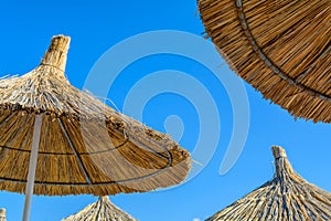 Parasol on the beach in a sunny summer day over a blue sky background