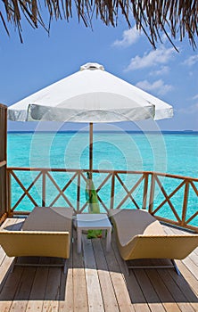 Parasol and chaise lounges on a terrace of water v photo