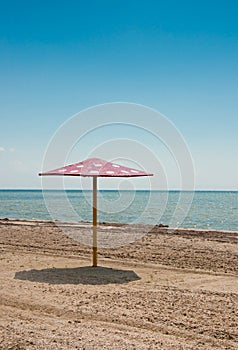 The parasol on empty sandy beach