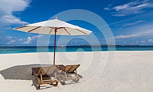 Parasol and sunbeds on the beach Atoll island Maldives