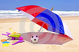 Parasol, toys and ball at the beach